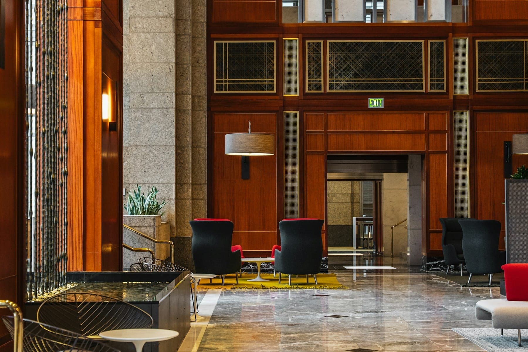 A hotel lobby with wood panelling, stone floors and modern seating